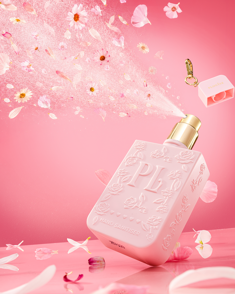 Bouteille rose de spray désinfectant pour les mains P.Louise au parfum signature avec bouchon doré sur fond rose avec des éléments floraux