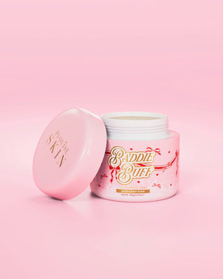 A pink P.Louise tub of Baddie Buff Scalp and Body Sugar Scrub in Coconut Coast with the lid off