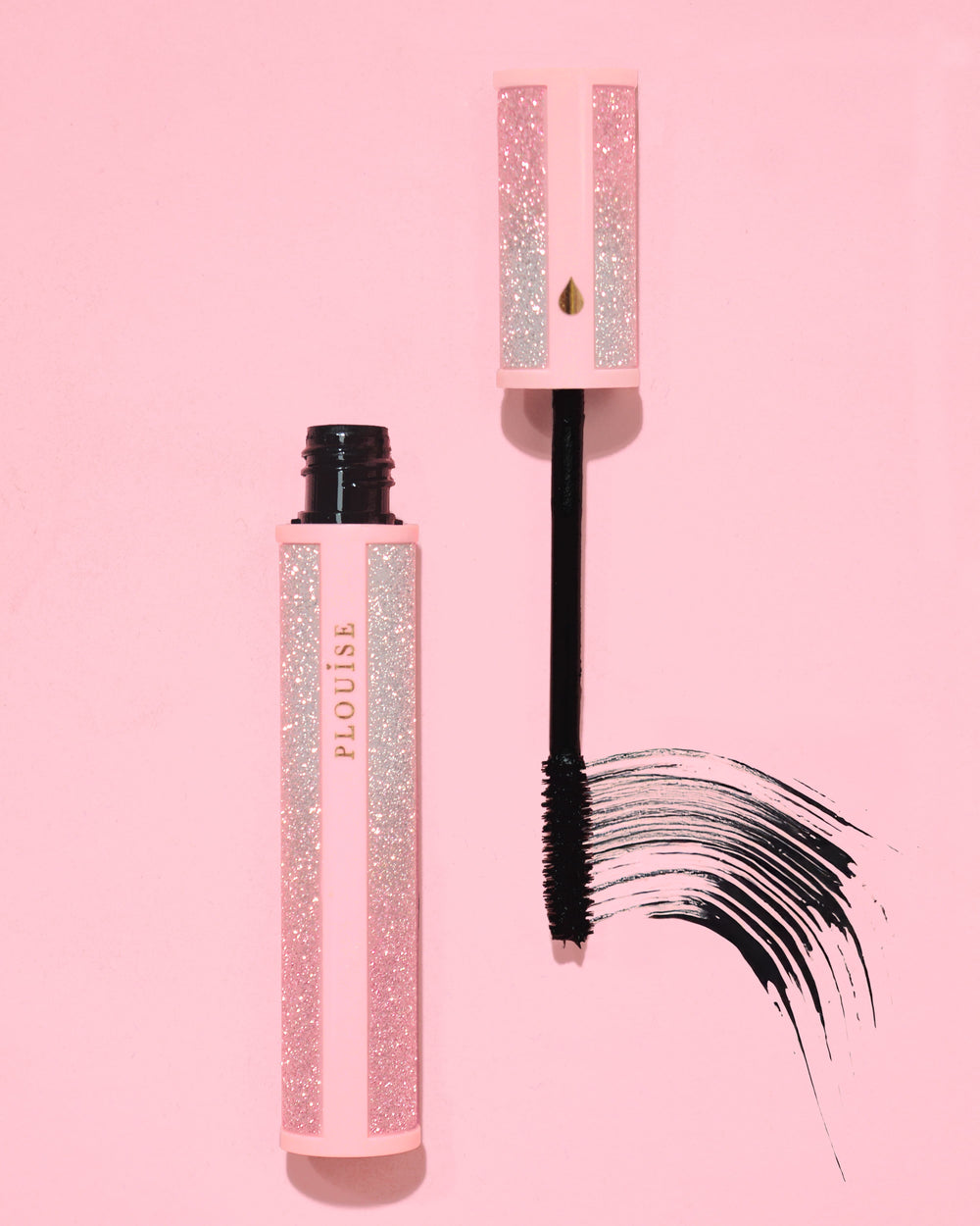 Mascara rosa glitterato P.Louise Cry Baby con bacchetta nera su sfondo rosa