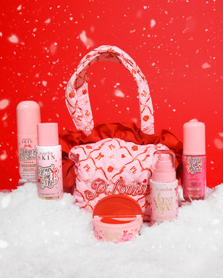 Festive P.Louise christmas bag with handle containing several skincare products on a red background surrounded by snow
