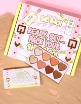 Emballage et produit de la palette pour le visage P.Louise All Over The Place présentés avec des nuances en forme de cœur de différentes couleurs sur un lit de sable.