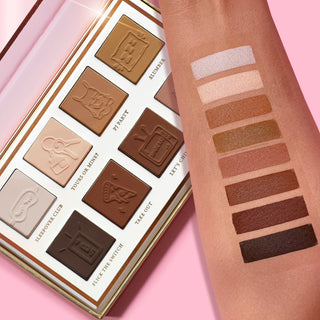 The P.Louise Love Tapes Beneath The Sheets Makeup Palette containing 8 velvety matte shades of eyeshadow with text labels for each shade, presented in a rose gold packaging with intricate designs with an arm featuring swatches of each shade
