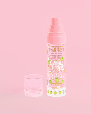 Bottle of P. Louise Sweet Spritz Apple Hydrating Face Mist with cap off on a pink background