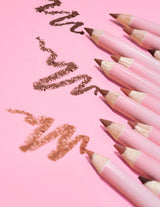 Une collection de crayons à lèvres aiguisables définition ultime P.Louise dans une variété de nuances nude, disposés sur un fond rose avec quelques lignes du produit dessinées sur la surface.
