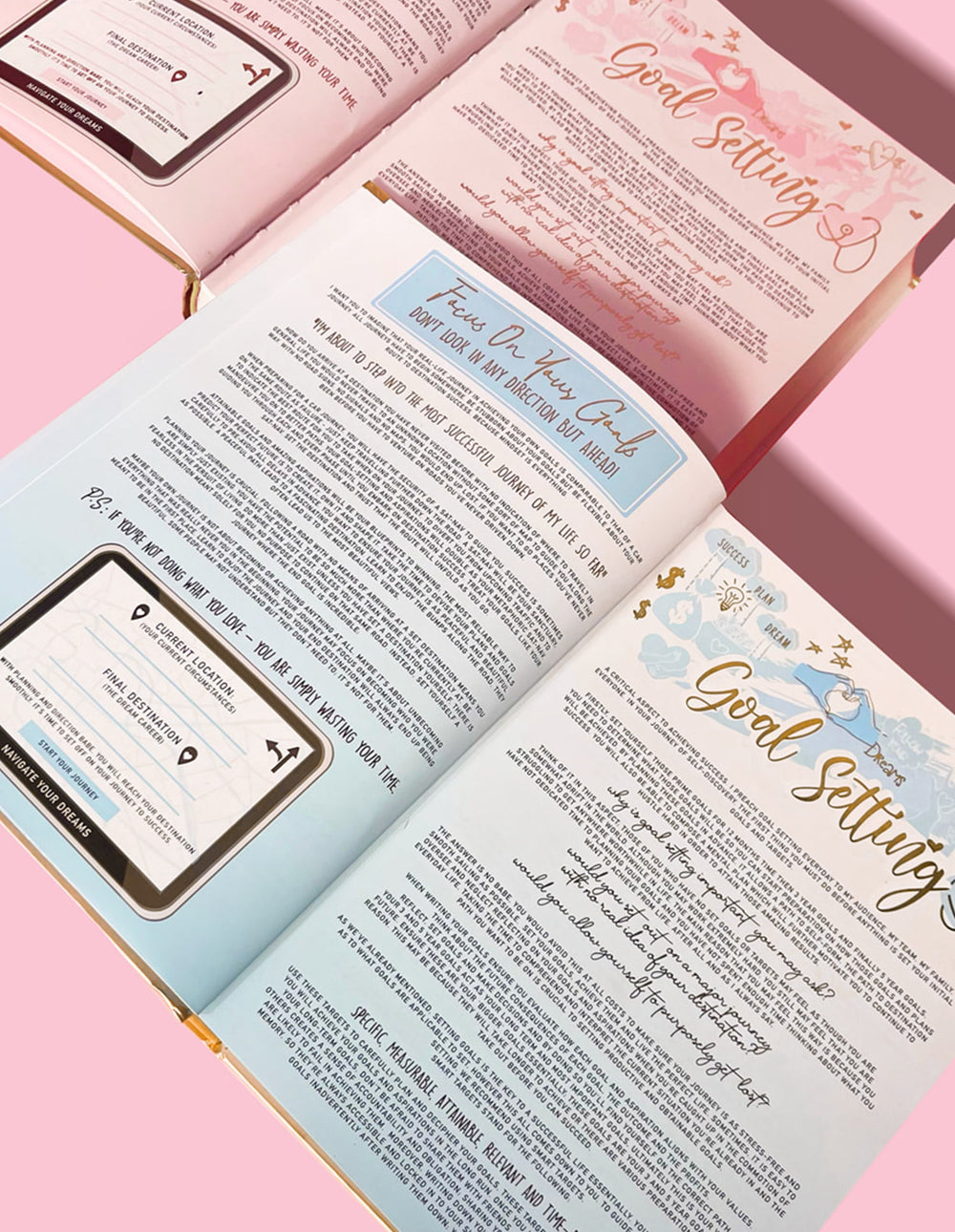 En inspirerende dagbok med flere synlige sider, som viser deler om målsetting og andre utviklingsemner, med rosa bakgrunn.